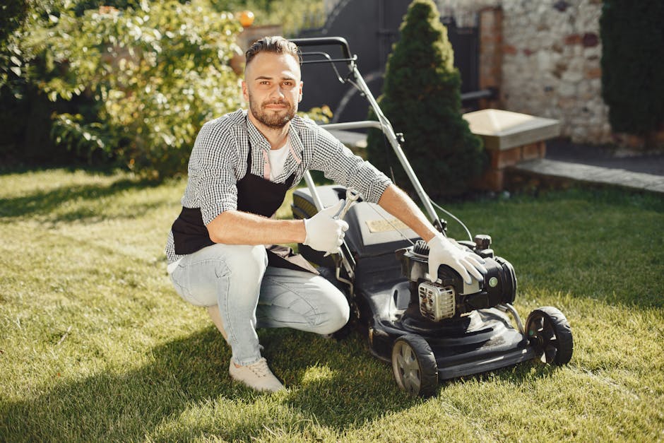 In a garden scene during daytime, a person wearing orange trousers and dark shoes is engaged in garden maintenance, using a rake or garden tool to clear overgrown grass and weeds from a lawn area. The